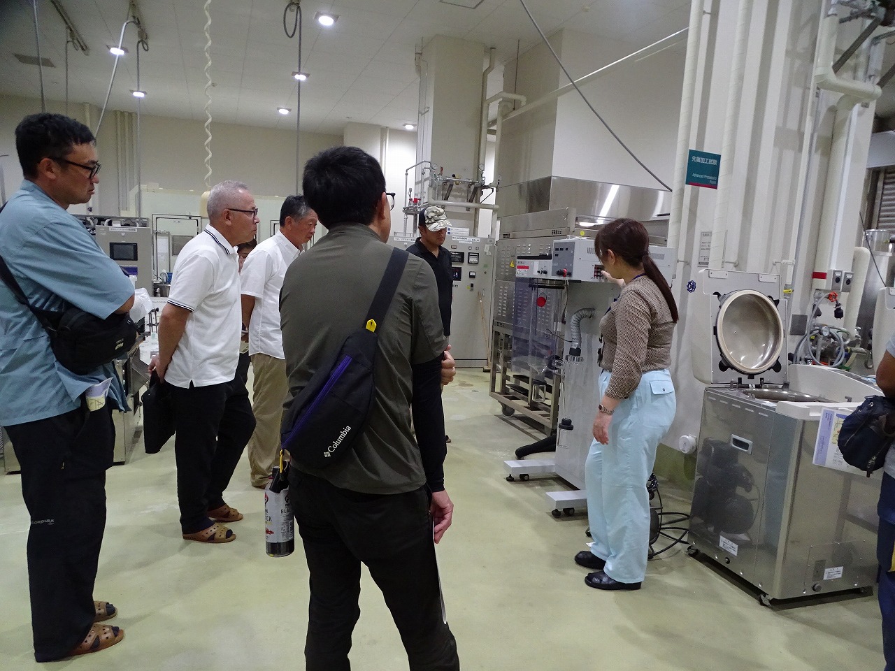 加工施設にある機械を見学する研修生